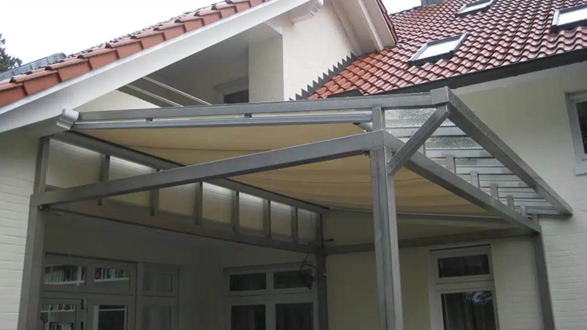 Moderne Terrassenüberdachung aus grauem Metall mit beigem Stoffdach